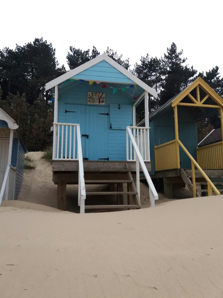 Colourful beach huts among the pine trees at Wells-next-the-Sea