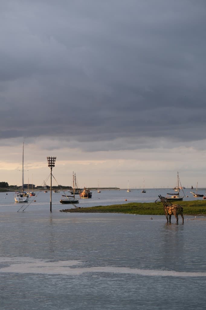 Boats moored on the water at Wells-next-the-Sea at sunset